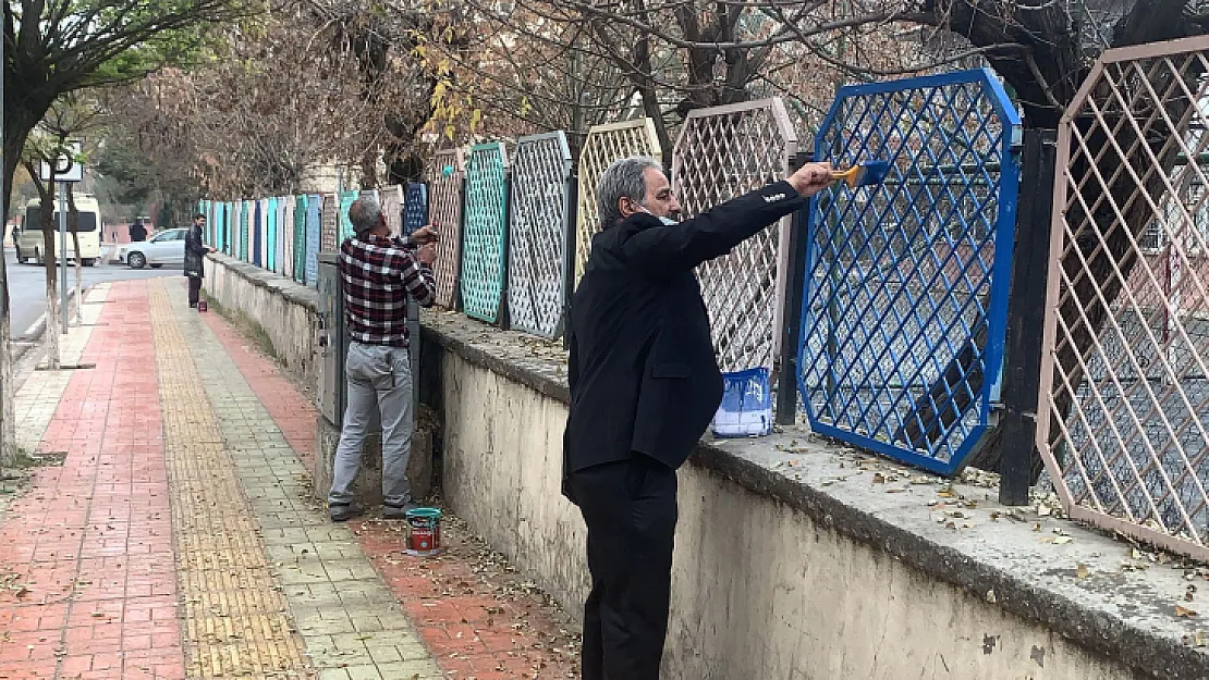 Okul müdürü elinde fırçayla okulu boyuyor