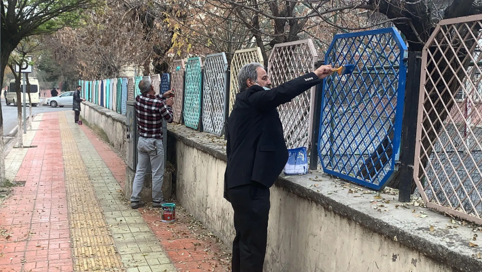 Okul müdürü elinde fırçayla okulu boyuyor